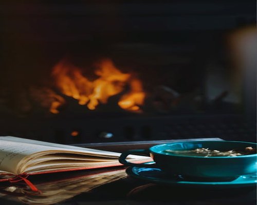 Person relaxing at home in the evening with a cup of tea