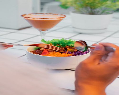 Asian woman eating a healthy bowl at a bright cafe